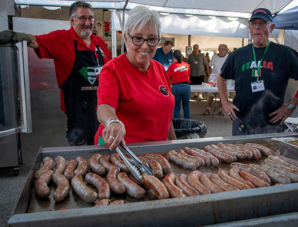 Kate Mercadante grills some of the 1,200 pounds of sweet and hot Italian sausage that will be served.