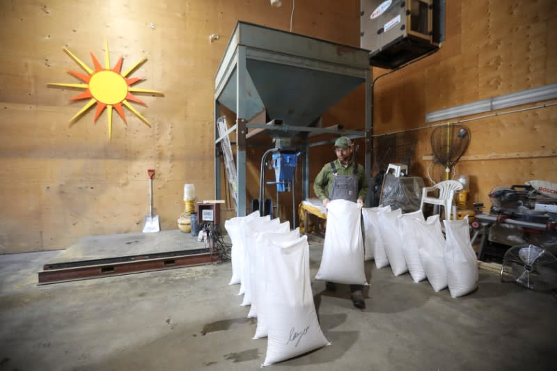 Farm manager fills bags of chicken feed at the Yukon Grain Farm near Whitehorse