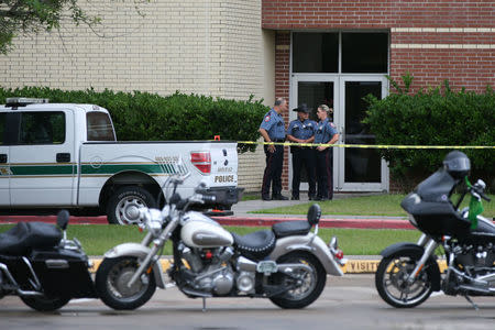 Law enforcement personnel stand guard at Santa Fe High School, where a recent shooting killed 10 victims, in Santa Fe, Texas, U.S., May 23, 2018. REUTERS/Loren Elliott