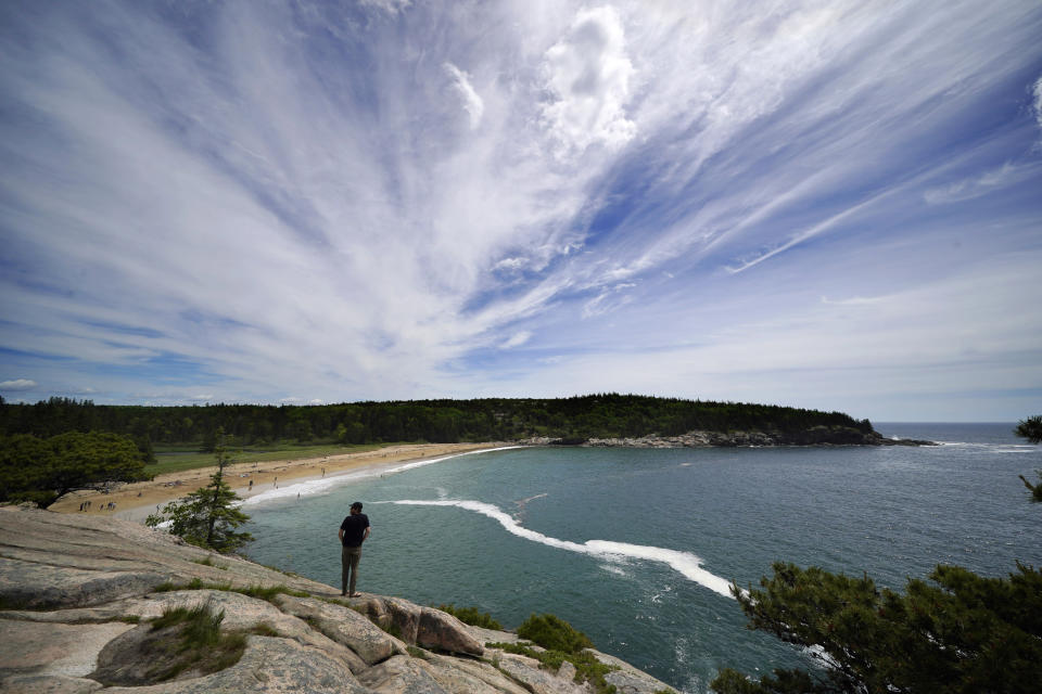 A man takes in the view of Sand Beach from a rocky overlook in Acadia National Park, Saturday, June 11, 2002, near Bar Harbor, Maine. The park will not have lifeguards on duty this summer due to worker and housing shortages. (AP Photo/Robert F. Bukaty)