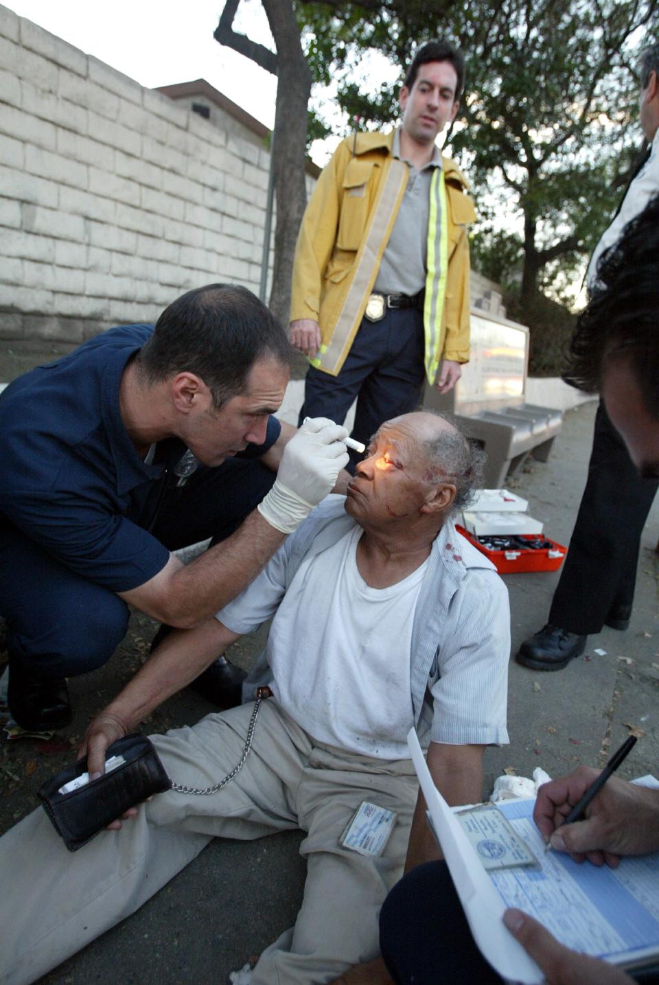 Marc Eckstein watches as emergency medical technician Cecco Secci checks Monroe Hall, 76, for a concussion after Monroe fell and hit his head in a South Central Los Angeles neighborhood on Nov. 21, 2002. Eckstein, EMS medical director for L.A. County, is trying to improve the overall quality of EMS in Los Angeles.  