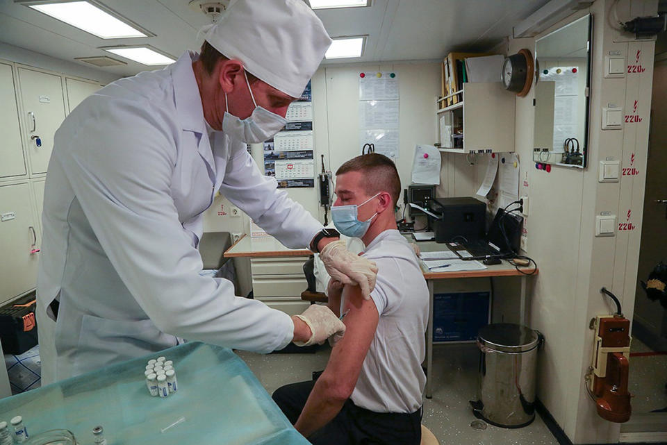 In this photo distributed by Russian Defense Ministry Press Service on Dec. 3, 2020, A Russian navy sailor gets a shot of a Russian COVID-19 vaccine in Severomorsk, Russia. The Russian navy this week started vaccinating crews against the coronavirus before they sail off on a mission. (Russian Defense Ministry Press Service via AP)