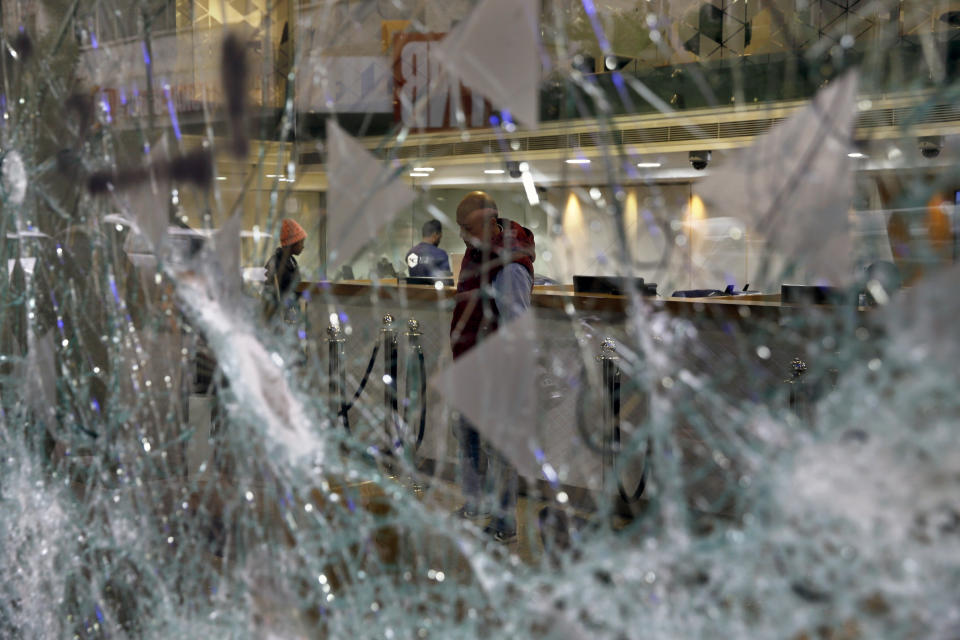 Bank employees are seen through the broken glass of Bank of Beirut that was smashed by anti-government protesters in Beirut, Lebanon, Wednesday, Jan. 15, 2020. Banks in Hamra trade street were badly damaged after a night that witnessed clashes between anti-government protesters and Lebanese riot police. (AP Photo/Bilal Hussein)