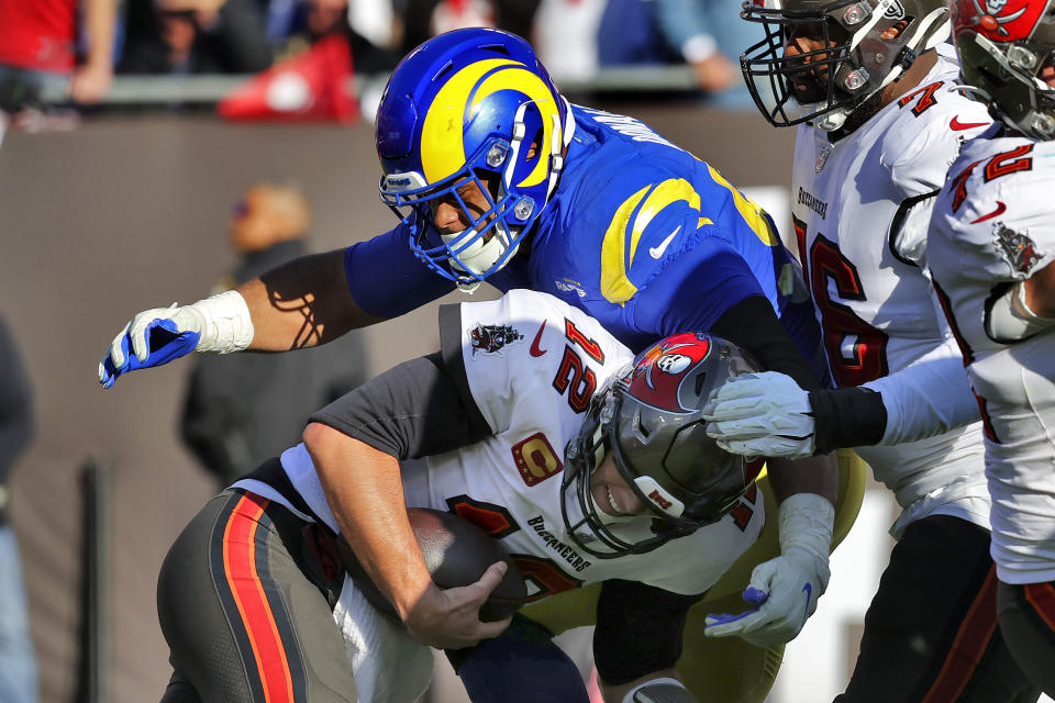 Los Angeles Rams defensive end Aaron Donald (99) sacks Tampa Bay Buccaneers quarterback Tom Brady (12) during the first half of an NFL divisional round playoff football game Sunday, Jan. 23, 2022, in Tampa, Fla. (AP Photo/Mark LoMoglio)