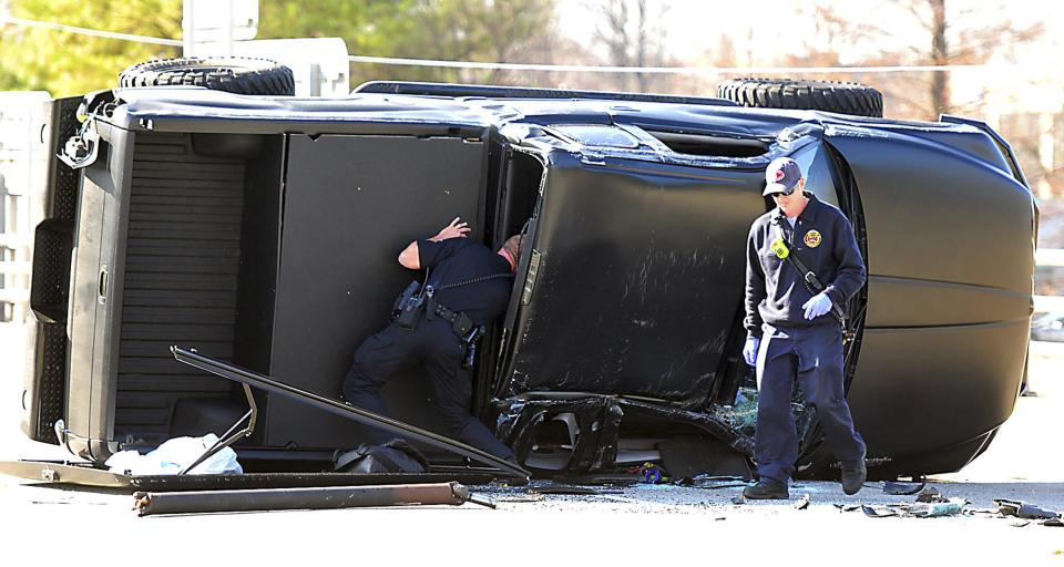 Police and fire officials examine Carolina Panthers quarterback Cam Newton's damaged truck following a crash in uptown Charlotte