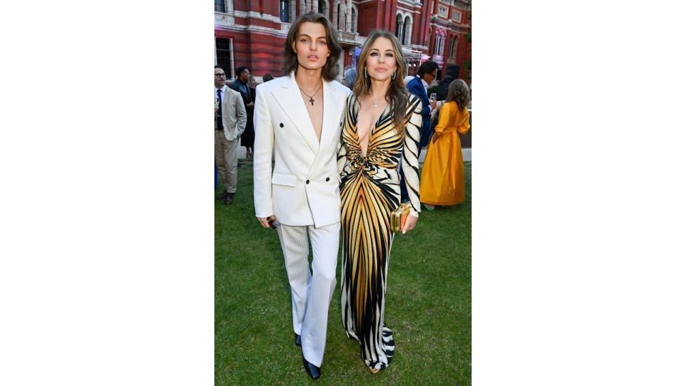 Damian Hurley in a white suit and Elizabeth Hurley in an animal-print dress