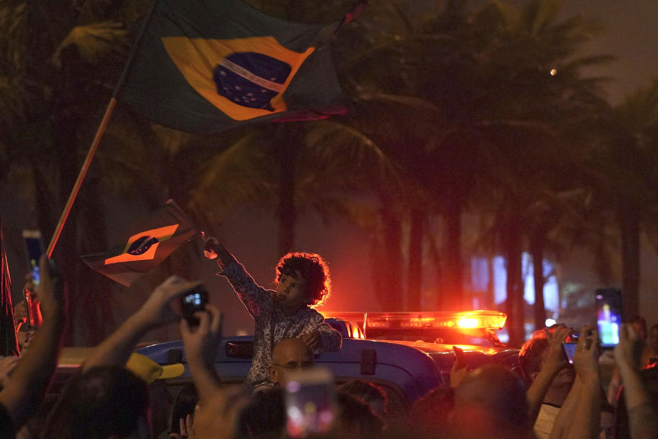 A boy waves a Brazilian flag during a celebration by supporters of Jair Bolsonaro of the Social Liberal Party, in Rio de Janeiro, Brazil, Sunday, Oct. 7, 2018. Official results showed that Fernando Haddad of the Workers' Party will face Jair Bolsonaro, the far-right congressman in a second-round vote. (AP Photo/Ricardo Borges)