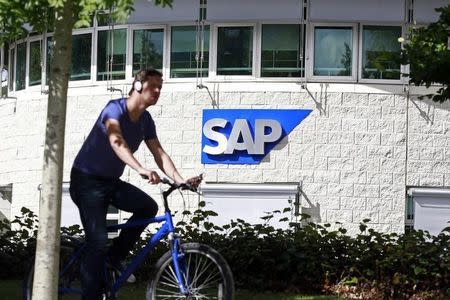 A man cycles past the SAP logo at its offices in the CityWest complex, Dublin September 5, 2013. REUTERS/Cathal McNaughton