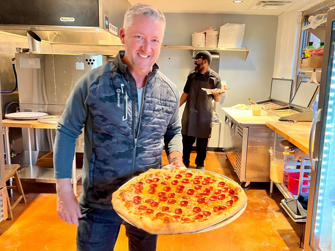 Chef Tim Love with his New York-style pizza by the slice at the Tannahill’s pizza shop.
