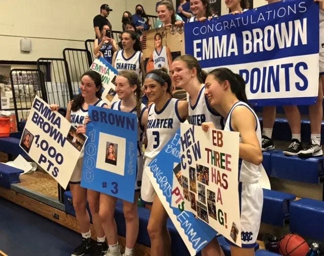 Emma Brown (3) celebrates with teammates after scoring her 1,000th career point.