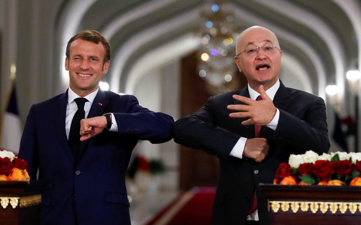 French President Emmanuel Macron and Iraq's President Barham Salihat greet each other with an elbow bump  - GONZALO FUENTES/ REUTERS