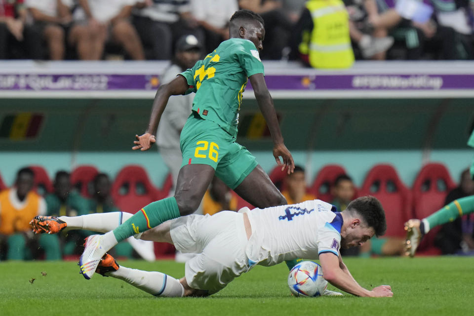 England's Declan Rice, right, challenges for the ball with Senegal's Pape Gueye during the World Cup round of 16 soccer match between England and Senegal, at the Al Bayt Stadium in Al Khor, Qatar, Sunday, Dec. 4, 2022. (AP Photo/Hassan Ammar)