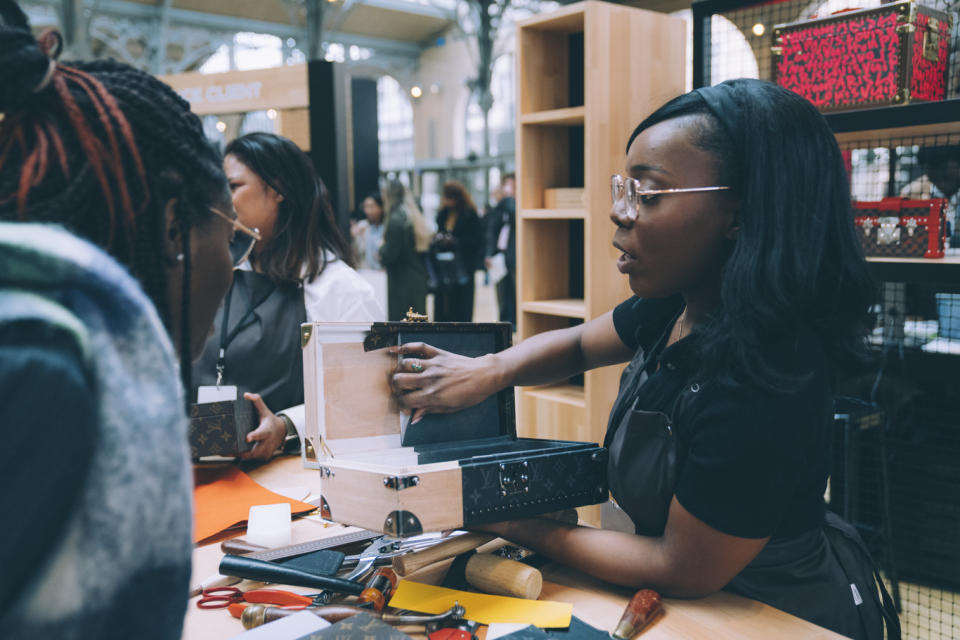 A Louis Vuitton employee explains the making of a trunk case at the “You and ME” recruitment fair in Paris.