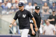 New York Yankees manager Aaron Boone, left, walks off the field after being ejected by umpire Sean Barber (29) in the ninth inning of a baseball game against the Oakland Athletics, Saturday, June 19, 2021, in New York. (AP Photo/John Minchillo)