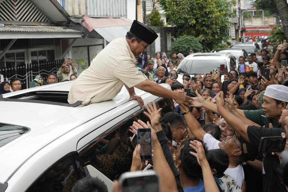 Indonesian Defense Minister and presidential frontrunner Prabowo Subianto greets supporters before visited the grave of Habib Ali bin Abdurrahman Al-Habsyi at the Al Riyadh Mosque in Jakarta, Indonesia, Friday, Feb. 16, 2024. Prabowo Subianto’s rise as Indonesia’s apparent next president is a dramatic comeback from a notorious past, which saw the United States banning his entry over human rights and the Indonesian army, where he led the special forces, expelling him. (AP Photo/Achmad Ibrahim)
