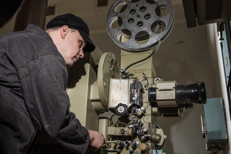 projectionist operating an old theater camera