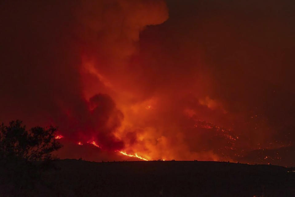 In this photo provided by Joseph Pacheco, a wildfire is seen burning in Globe, Ariz., on Monday, June 7, 2021. Firefighters in Arizona were fighting Tuesday to gain a foothold into a massive wildfire, one of two that has forced thousands of evacuations in rural towns and closed almost every major highway out of the area. (Joseph Pacheco via AP)