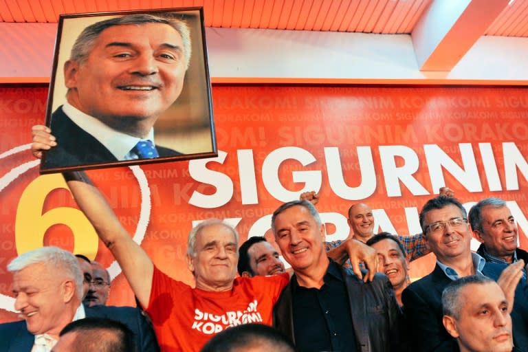 Montenegrin Prime Minister Milo Djukanovic poses next to supporters during celebrations after parliamentary elections in Podgorica on October 17, 2016