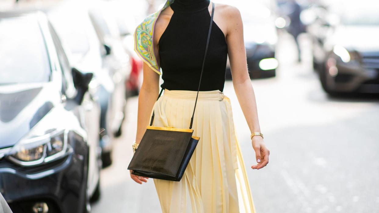 a woman wears a yellow skirt and black tank