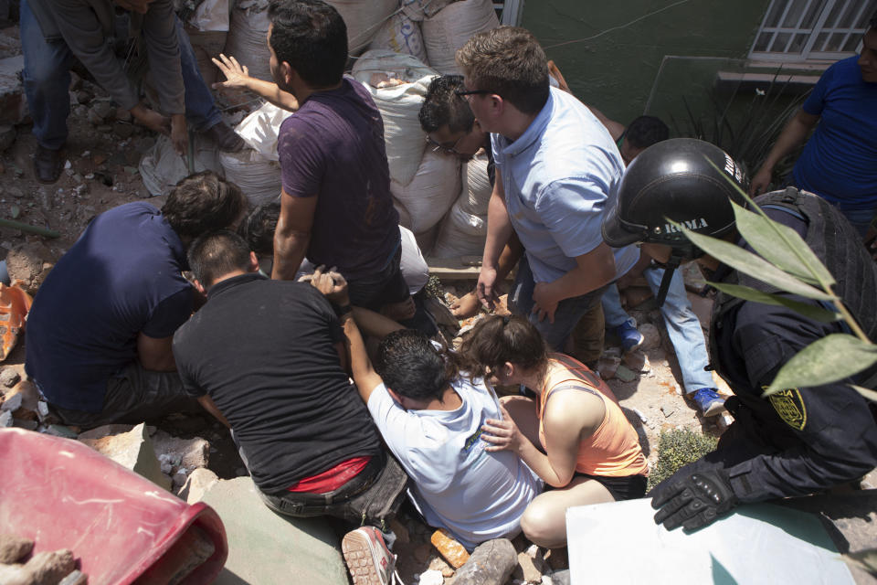 La gente ayuda para sacar a un hombre atrapado tras el colapso de un edificio en el barrio de Condesa. (AP Photo/Pablo Ramos)