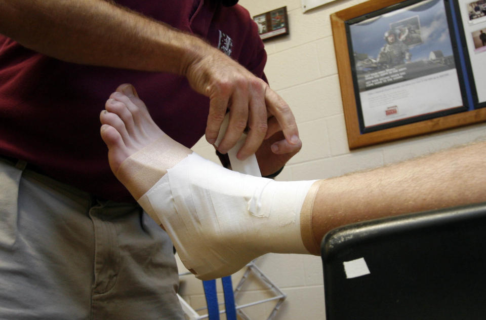 Salesianum athletic trainer Joe Szczerba tapes an ankle.