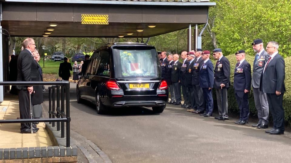 Army veterans standing next to a hearse 