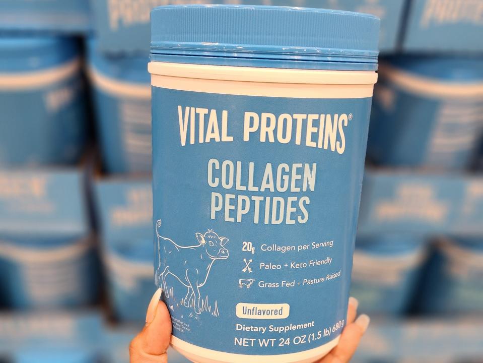 The writer holds a blue container of Vital Proteins collagen peptides