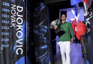 Serbia's Novak Djokovic carries the Norman Brookes Challenge Cup onto Margaret Court Arena after defeating Austria's Dominic Thiem in the men's singles final of the Australian Open tennis championship in Melbourne, Australia, early Monday, Feb. 3, 2020. (AP Photo/Andy Brownbill)