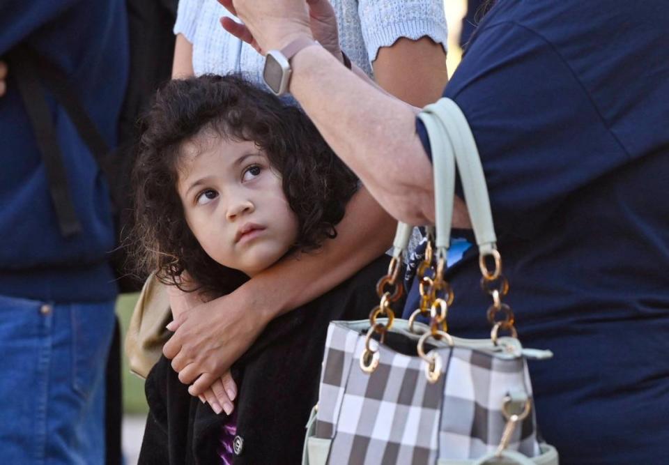 Lily Wichapool, 5, looks across to protesters as she stands in the arms of her mother Desiree Ledezma as the City of Fresno raised an Israeli flag in solidarity with Israel in a ceremony at Eaton Plaza Thursday, Oct. 12, 2023 in downtown Fresno. Lily and her mother attend Temple Beth Israel.