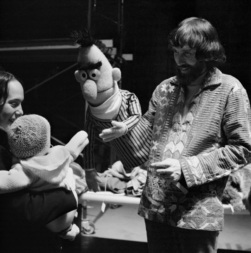 Jim Henson is seen holding Bert as he entertains a baby during rehearsals for the show at Reeves TeleTape Studio in 1970 in N.Y.C.