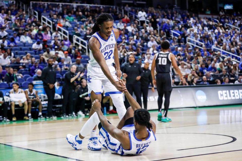 Kentucky freshman Cason Wallace helps up senior teammate Antonio Reeves during Friday’s win over Providence.