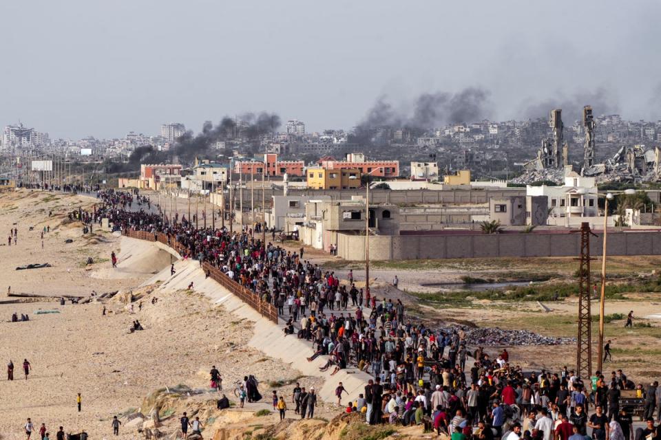 Palestinians wait for aid trucks to cross in central Gaza Strip on Sunday amid widespread famine in the enclave (AP)