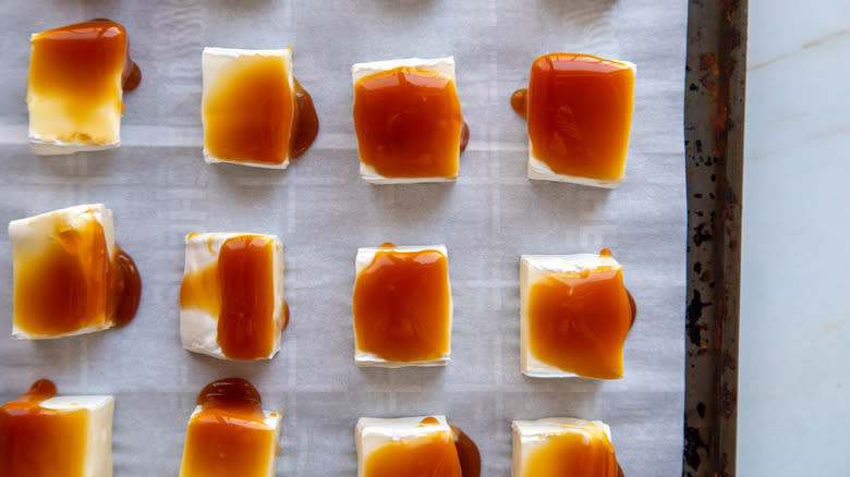 brie chunks with caramel sauce on sheet pan