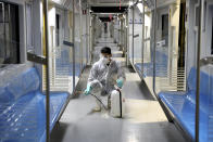 FILE - In this Feb. 26, 2020, file photo, a worker disinfects subway trains against coronavirus in Tehran, Iran. As the coronavirus spreads around the world, International health authorities are hoping countries can learn a few lessons from China, namely, that quarantines can be effective and acting fast is crucial. On the other hand, the question before the world is to what extent it can and wants to replicate China’s draconian methods. (AP Photo/Ebrahim Noroozi, File)