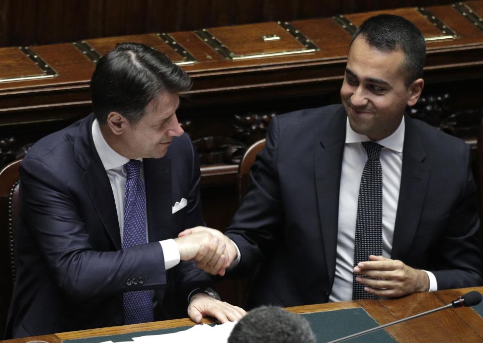 Italian Premier Giuseppe Conte shakes hands with Foreign Minister Luigi Di Maio after addressing parliament ahead of confidence vote later at the Lower Chamber in Rome, Monday, Sept. 9, 2019. The 5-Stars-PD alliance was the unexpected result of Italy's mid-summer crisis, which began when the League's Matteo Salvini, then the powerful interior minister and deputy premier, pulled the plug on the coalition hoping to trigger snap elections and win the premiership.(AP Photo/Andrew Medichini)