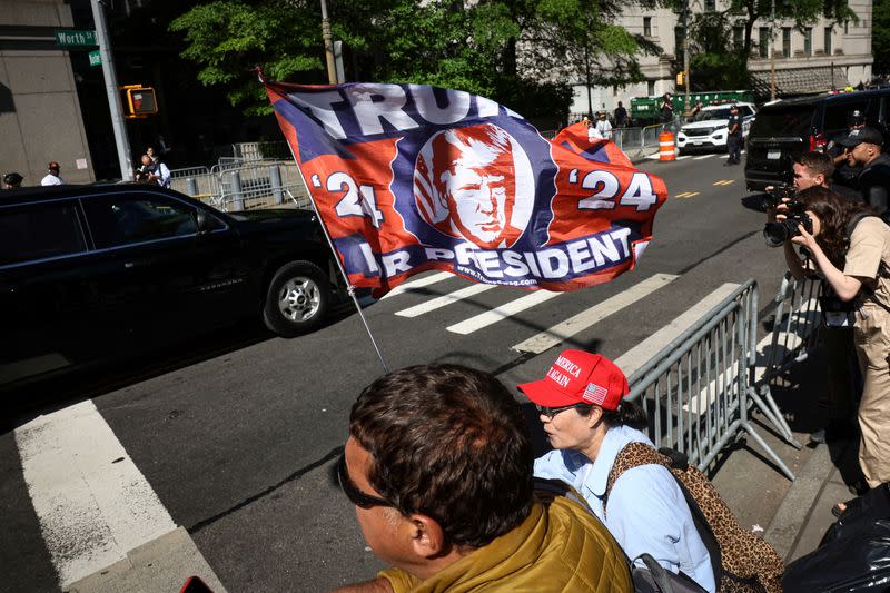 Supporters of Republican presidential candidate and former U.S. president Donald Trump greet as his motorcade as it arrives at courthouse in New York