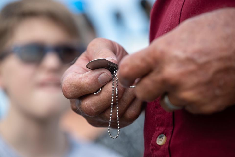 Larry Mayfield, the nephew of World War II U.S. Army Air Force Sgt. Herald Ray Boyd, looks at his uncle's dog tags at Corpus Christi International Airport on Friday, Sept. 9, 2022, in Texas. The remains of the fallen soldier were returned home after 77 years abroad.