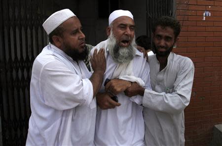 A man (C) cries over the death of his brother, who was killed in a bomb blast, at a hospital in Peshawar September 27, 2013. REUTERS/Fayaz AziZ