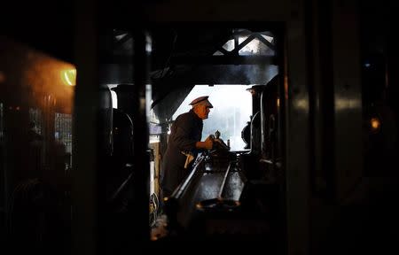 Puffing Billy steam engine fireman Barry Rogers, 70, wipes down locomotive 12A in the shed before hauling a train from Belgrave near Melbourne, October 20, 2014. REUTERS/Jason Reed