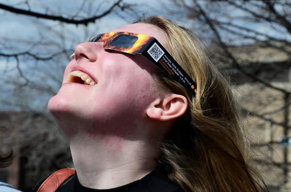 Melanie Carlson of Howell takes delight in watching the solar eclipse on Monday, April 8, 2024 at the Petoskey District Library.