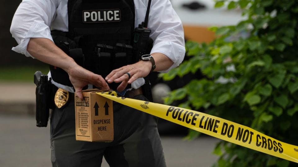 <div>FILE-A police officer unravels police tape at crime scene. (Aimee Dilger/SOPA Images/LightRocket via Getty Images)</div>