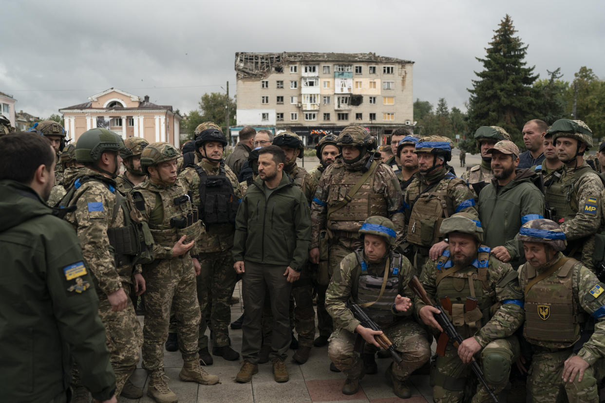 Ukrainian President Volodymyr Zelenskyy stands with soldiers after attending a national flag-raising ceremony in the freed Izium, Ukraine, Wednesday, Sept. 14, 2022. Zelenskyy visited the recently liberated city on Wednesday, greeting soldiers and thanking them for their efforts in retaking the area, as the Ukrainian flag was raised in front of the burned-out city hall building. (AP Photo/Leo Correa)
