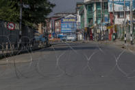 A barbwire blocks a deserted street on the first anniversary of India’s decision to revoke the disputed region’s semi-autonomy, in Srinagar, Indian controlled Kashmir, Wednesday, Aug. 5, 2020. Last year on Aug. 5, India’s Hindu-nationalist-led government of Prime Minister Narendra Modi stripped Jammu-Kashmir of its statehood and divided it into two federally governed territories. Late Tuesday, authorities lifted a curfew in Srinagar but said restrictions on public movement, transport and commercial activities would continue because of the coronavirus pandemic. (AP Photo/ Dar Yasin)