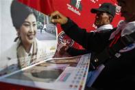 Members of the "Volunteers' Ward to protect the Nation's Democracy" group hold pictures of Thailand's Prime Minister Yingluck Shinawatra during their two days training at the stadium in Nakhon Ratchasima, Northeastern province of Thailand, April 21, 2014. REUTERS/Athit Perawongmetha