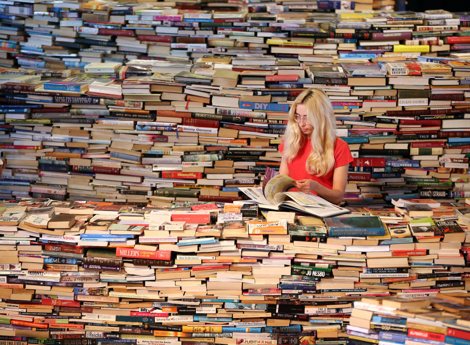 LONDON, ENGLAND - JULY 31: Employee Tilly Shiner looks at a book in the aMAZEme labyrinth at The Southbank Centre on July 31, 2012 in London, England. Brazilian artists Marcos Saboya and Gualter Pupo used 250,000 books to create the maze which will be on display until August 25, 2012. (Photo by Peter Macdiarmid/Getty Images)