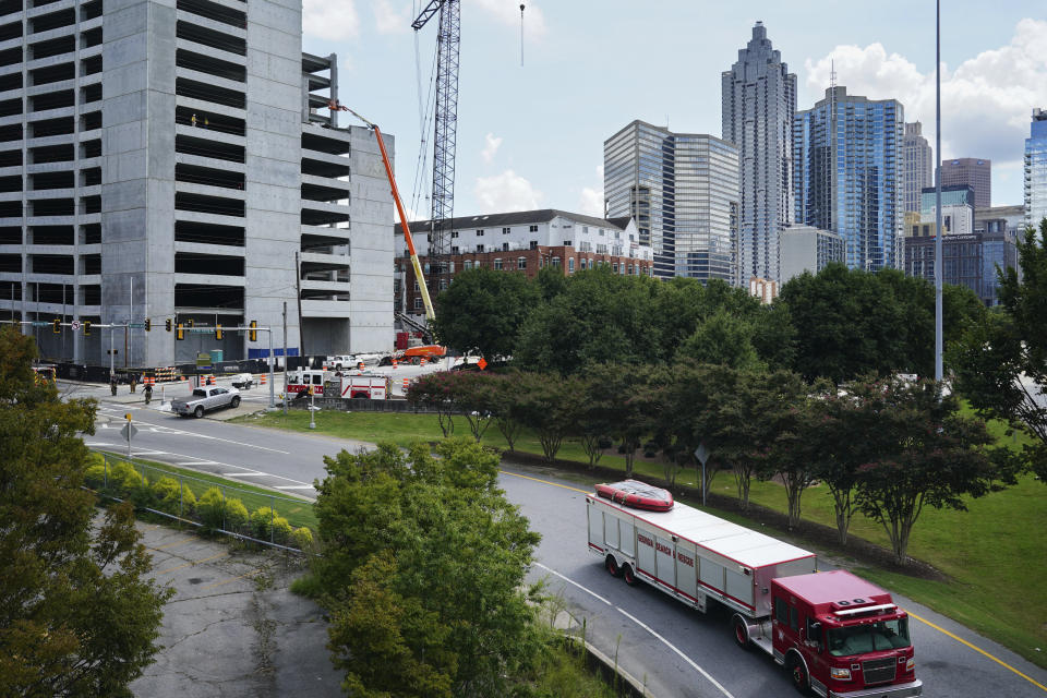 An emergency vehicle leaves the scene of a parking deck under construction after it partially collapsed, injuring several workers, on Friday, Sept. 11, 2020, in Atlanta. (AP Photo/Elijah Nouvelage)
