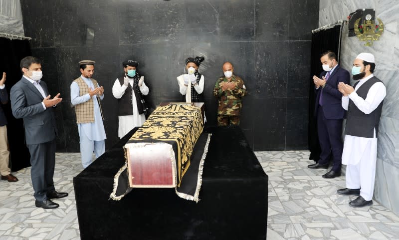 Afghanistan's President Ashraf Ghani prays over the coffin of Ayaz Niazi, a well-known scholar, who was killed last night by a bomb blast in Kabul