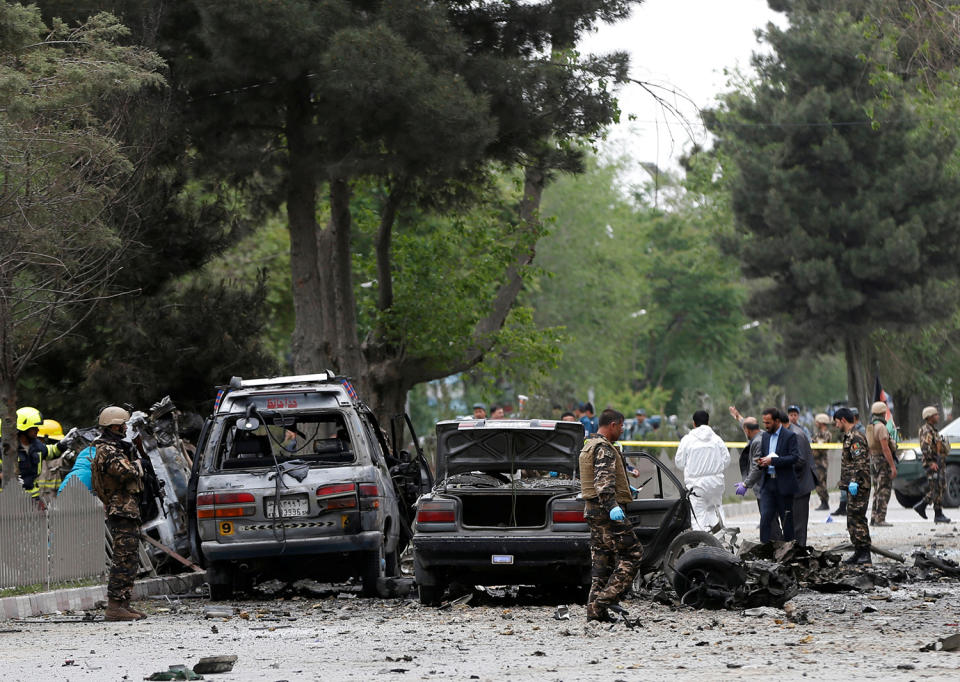 Afghan security forces inspect the site of a suicide attack in Kabul