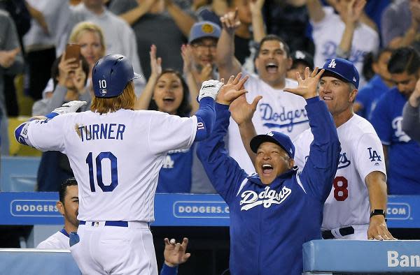 Justin Turner is congratulated after hitting the game-tying home run during Saturday's game against the Phillies. Yasiel Puig, Cody Bellinger and Turner went back-to-back-to-back during the inning. (AP)