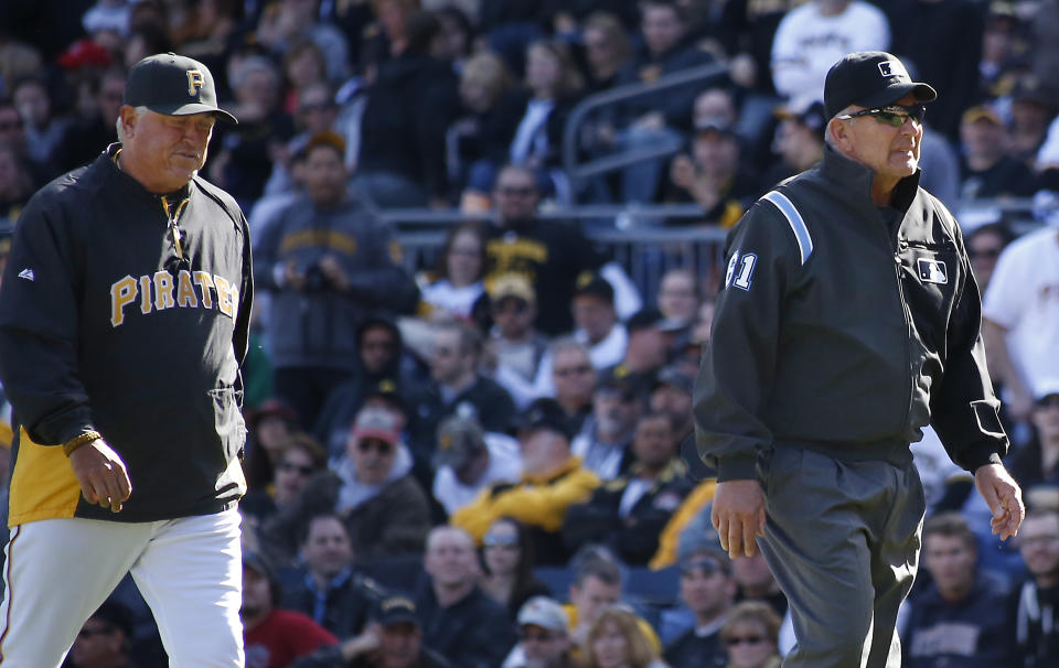 Pittsburgh Pirates manager Clint Hurdle, left, follows first base umpire Bob Davidson, from the field after he requested a review on a safe call at first on a pickoff attempt in the tenth inning of the opening day baseball game against the Chicago Cubs on Monday, March 31, 2014, in Pittsburgh. Cubs' Emilio Bonifacio was called safe but the call was overturned on the review requested by Hurdle and Bonifacio was ruled out. The Pirates won 1-0 in ten innings.(AP Photo/Keith Srakocic)